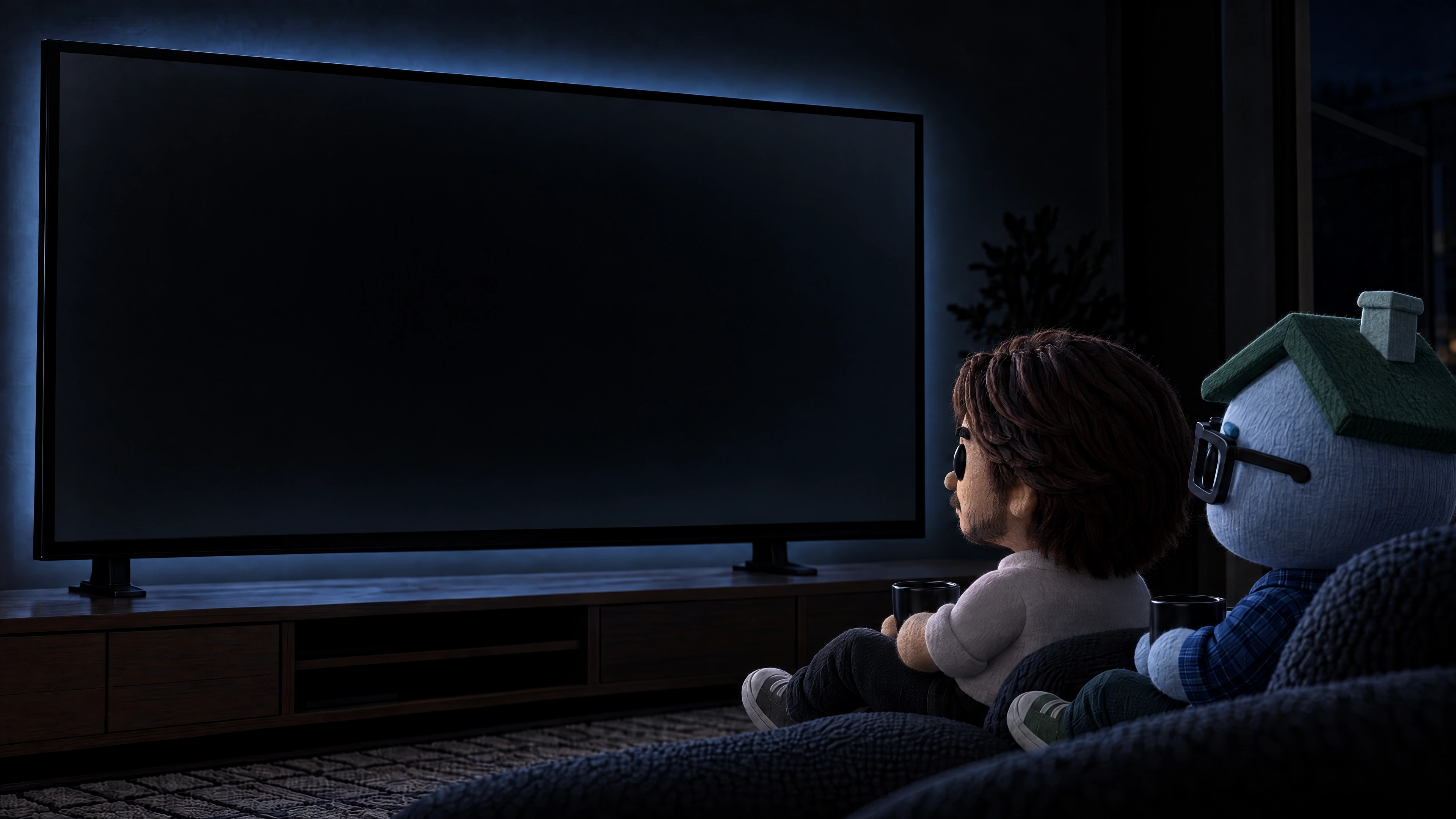 Two handmade characters seated in a dark room in front of the CodeMen monitor